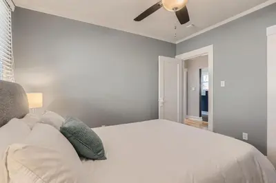 a bedroom with a white bed with a ceiling fan at Highlands Bungalow With A Back Yard And A Fire Pit in Denver