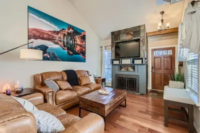 a living room with leather furniture and a flat screen tv at Pet Friendly Townhome WIth A Fireplace And A King Bed In Littleton in Littleton