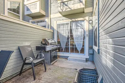 a chair sitting in front of a house with a grill at Pet Friendly Townhome WIth A Fireplace And A King Bed In Littleton in Littleton