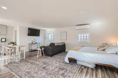 a bedroom with a bed and a living room at Pet Friendly Carriage House Near Red Rocks And Regis in Denver