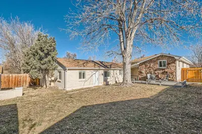 a stone house with a tree in the yard at Pet Friendly Carriage House Near Red Rocks And Regis in Denver