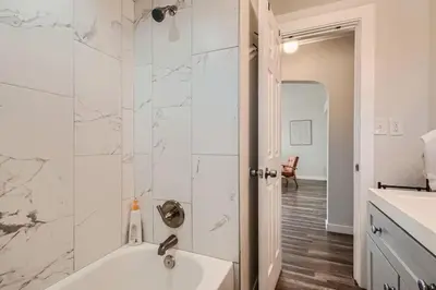 a white bathroom with a tub and a sink at 4 Bedroom Bungalow Pet Friendly Near Regis And Red Rocks And Tennyson in Denver