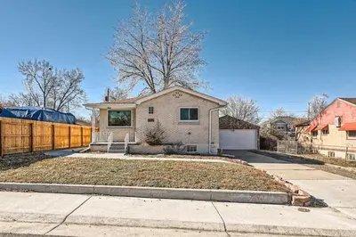 a white house with a fence and a driveway at 4 Bedroom Bungalow Pet Friendly Near Regis And Red Rocks And Tennyson in Denver