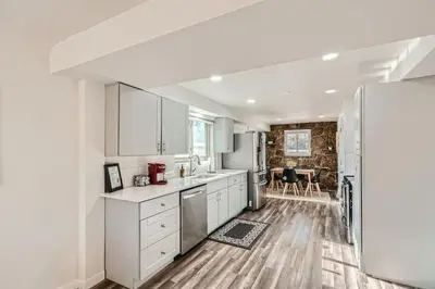 a kitchen with white cabinets and a refrigerator at 4 Bedroom Bungalow Pet Friendly Near Regis And Red Rocks And Tennyson in Denver