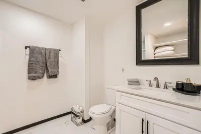 a white bathroom with a toilet and a mirror at Modern Home In West Denver 15 Min Close To Downtown in Westminster