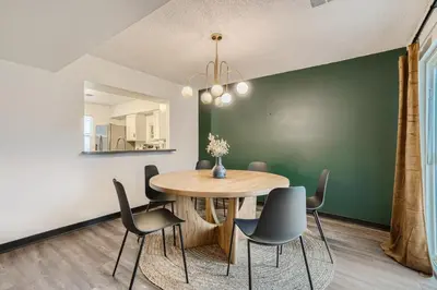 a dining room with a wooden table and chairs at Modern Home In West Denver 15 Min Close To Downtown in Westminster