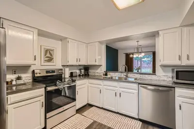 a large white kitchen with white cabinets and appliances at Modern Home In West Denver 15 Min Close To Downtown in Westminster
