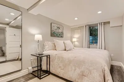 a bedroom with a large bed and a mirror at Guest Suite At Hilltop And Cherry Creek Near to Museums in Denver