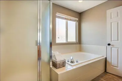 a bathroom with a tub and a sink and a window at Near to DIA Airport retreat And 20 Min To Downtown Denver in Henderson