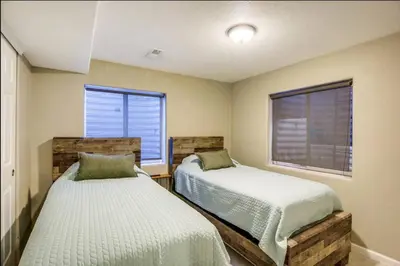 two beds in a room with two windows at Near to DIA Airport retreat And 20 Min To Downtown Denver in Henderson
