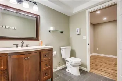 a bathroom with a toilet and a sink and a mirror at Near to DIA Airport retreat And 20 Min To Downtown Denver in Henderson