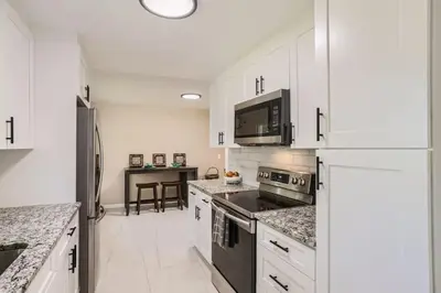 a kitchen with white cabinets and a black appliances at Pet Friendly 3 Bedroom Near to Red Rocks And Belmar In Denver in Lakewood