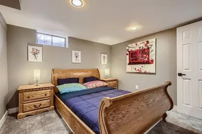 a bedroom with a wooden bed and a wooden dresser at Basement Guest Suite With A Pool Table A Hot Tub And A TV in Denver