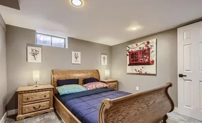 a bedroom with a wooden bed and a wooden dresser at Basement Guest Suite With A Pool Table A Hot Tub And A TV in Denver