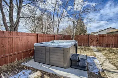 a hot tub in a yard next to a fence at Basement Guest Suite With A Pool Table A Hot Tub And A TV in Denver