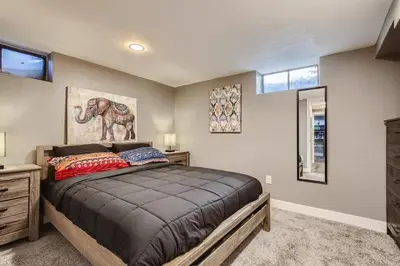 a bedroom with a bed and a painting of an elephant at Basement Guest Suite With A Pool Table A Hot Tub And A TV in Denver