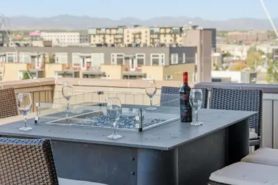 a table with glasses and a bottle of wine on a balcony at Ultra Luxury Loft With A Fireplace In The Rooftop In RiNo in Denver