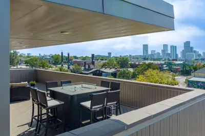 a balcony with a table and chairs and a view of the city at Ultra Luxury Loft With A Fireplace In The Rooftop In RiNo in Denver