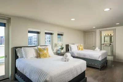 a bedroom with two beds and a table and windows at Ultra Luxury Loft With A Fireplace In The Rooftop In RiNo in Denver