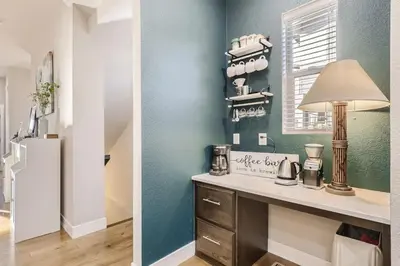 a kitchen with a table with a lamp and a refrigerator at New Central Park Home Near DIA And 20mins to Downtown in Denver
