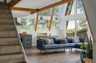 a living room with a blue couch and some windows at Beautiful A Frame Near Hiking And Red Rocks And Evergreen in Morrison