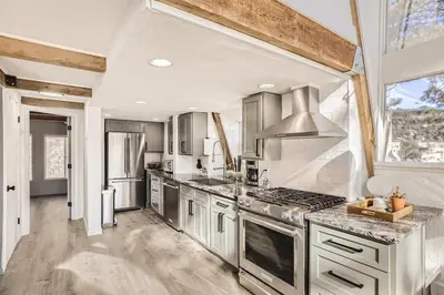 a kitchen with stainless steel appliances and a large window at Beautiful A Frame Near Hiking And Red Rocks And Evergreen in Morrison