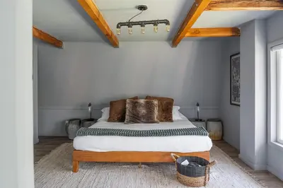 a bedroom with a bed in a white room at Beautiful A Frame Near Hiking And Red Rocks And Evergreen in Morrison