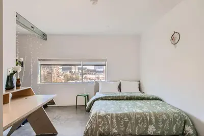 a bedroom with a bed and a desk and a window at New Hip Loft Near RiNo Taxi District With A Pool in Denver