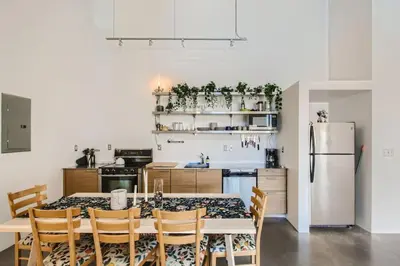 a kitchen with a table with chairs and a refrigerator at New Hip Loft Near RiNo Taxi District With A Pool in Denver