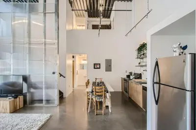 a kitchen with a refrigerator and a table with chairs at New Hip Loft Near RiNo Taxi District With A Pool in Denver