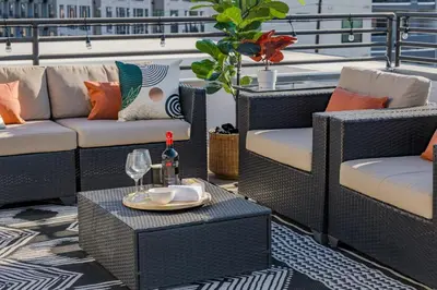 a patio with couches and a table with a glass of wine at RiNo Loft With Parking And Mountain Views in Denver