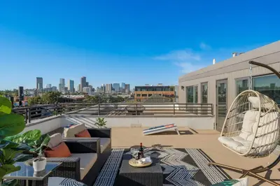 a balcony with chairs and tables on a building at RiNo Loft With Parking And Mountain Views in Denver
