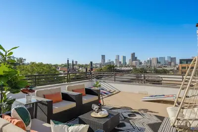 a view of the city from the roof of a building at RiNo Loft With Parking And Mountain Views in Denver