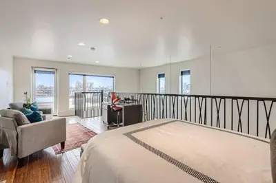 a bedroom with a large bed and a balcony at Luxury Loft With Skyline Viwes In RiNo in Denver