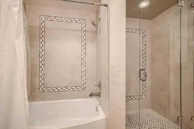a bathroom with a tub and a glass shower at Luxury Loft With Skyline Viwes In RiNo in Denver