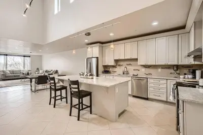 a large kitchen with white cabinets and a large island at Luxury Loft With Skyline Viwes In RiNo in Denver