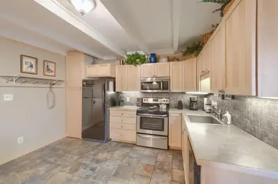 a kitchen with wooden cabinets and stainless steel appliances at Pet Friendly With A Fireplace A Pool Near Mountain Biking And Skiing in Silverthorne