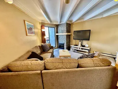 a living room with a large couch and a flat screen tv at Pet Friendly With A Fireplace A Pool Near Mountain Biking And Skiing in Silverthorne