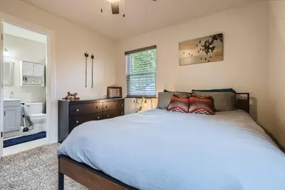 a bedroom with a large bed and a bathroom at Pet Friendly In West Denver Bungalow Near Meow Wolf in Denver