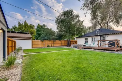 a yard with a white house and a fence at Pet Friendly In West Denver Bungalow Near Meow Wolf in Denver