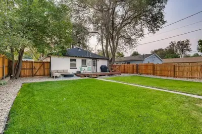 a backyard with a fence and green grass at Pet Friendly In West Denver Bungalow Near Meow Wolf in Denver