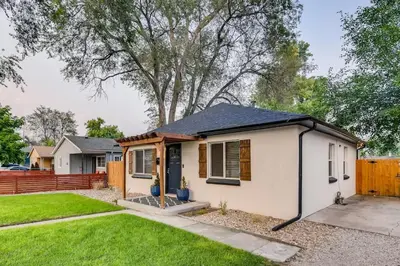a small white house with a fence at Pet Friendly In West Denver Bungalow Near Meow Wolf in Denver
