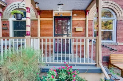a front porch of a brick house with a white railing at Central Denver Townhome Close To Historic Neighborhood in Denver