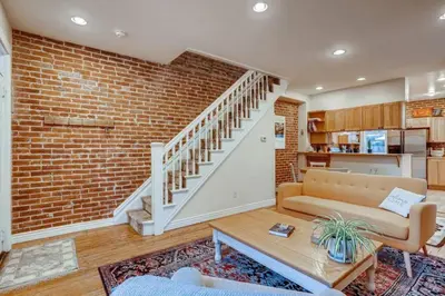 a living room with a couch and a brick wall at Central Denver Townhome Close To Historic Neighborhood in Denver