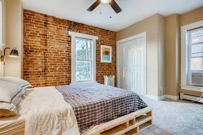 a bedroom with a brick wall and a bed at Central Denver Townhome Close To Historic Neighborhood in Denver