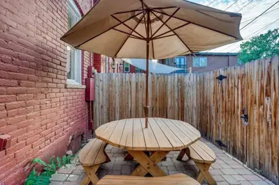 a wooden table with an umbrella on a patio at Central Denver Townhome Close To Historic Neighborhood in Denver