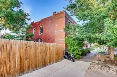 a wooden fence in front of a brick building at Central Denver Townhome Close To Historic Neighborhood in Denver