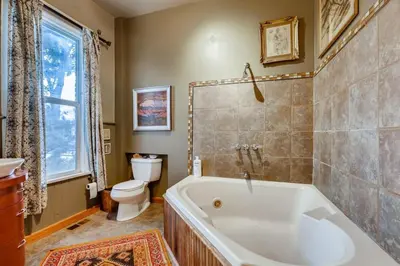 a bathroom with a tub and a toilet at Artsy Victorian Great Location And Amazing Outdoor Space in Denver