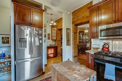 a kitchen with a stainless steel refrigerator and wooden cabinets at Artsy Victorian Great Location And Amazing Outdoor Space in Denver