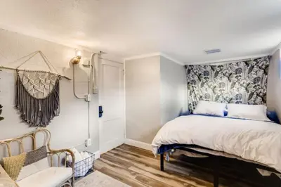 a bedroom with a bed and a chair at Guest Suite With Kitchenette And A 5 star Location in Denver
